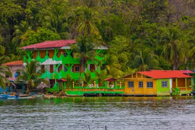 Colorful waterfront houses framed by rainforest at Isla Grande, Colón