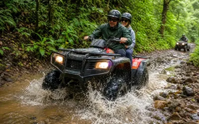 Couple riding an ATV through a shallow stream crossing
