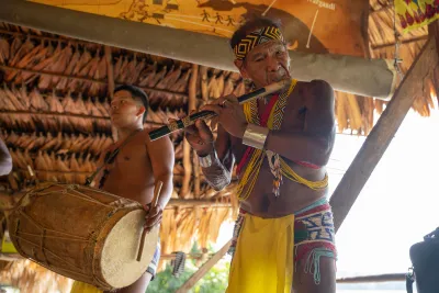 Emberá drummer welcoming visitors inside the village bohio