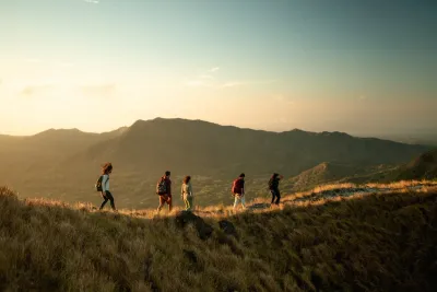 Hikers crossing the India Dormida ridge above El Valle de Antón at golden hour