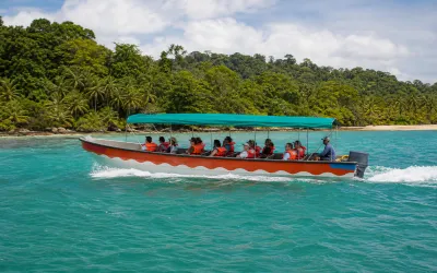 Covered tour boat crossing Caribbean water near Isla Grande